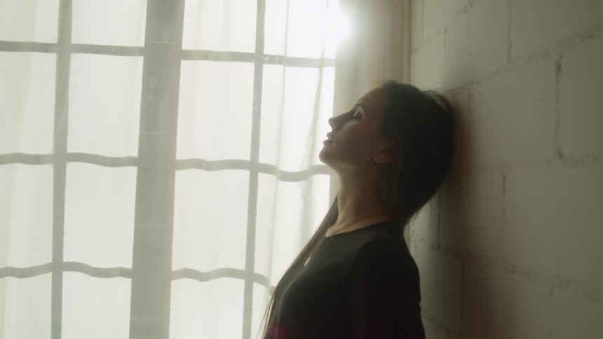 A woman is standing in a room and resting