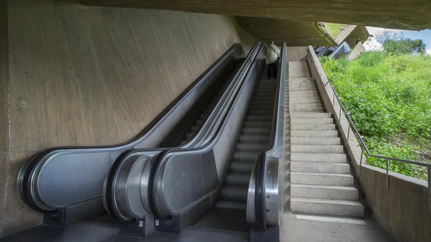Time lapse of people going up and down an escalator and stairs