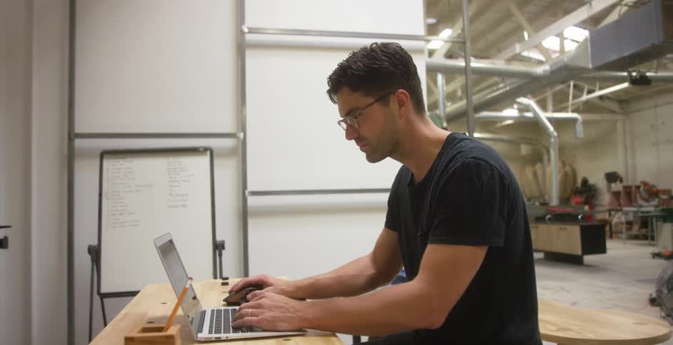 Man working on laptop in his workshop