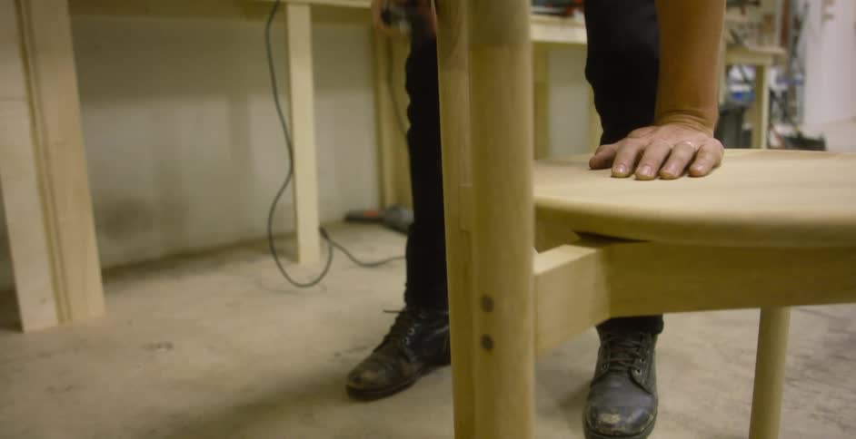Craftsman sanding a custom chair