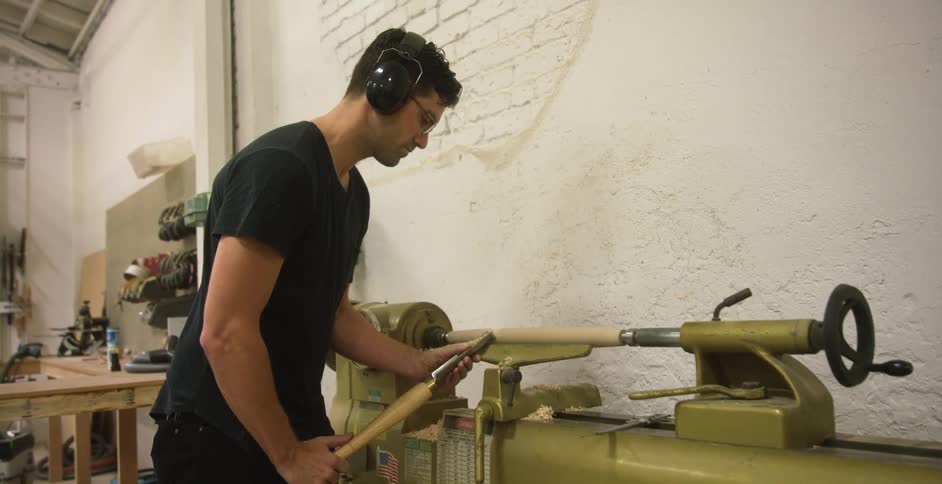 Craftsman chiseling wood with a lathe