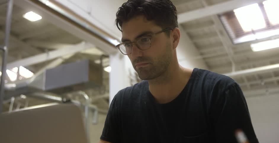 Man working on laptop in workshop