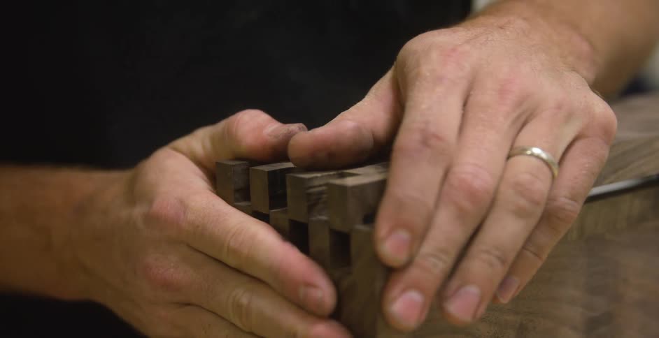 Closeup of gritty hands constructing wooden object