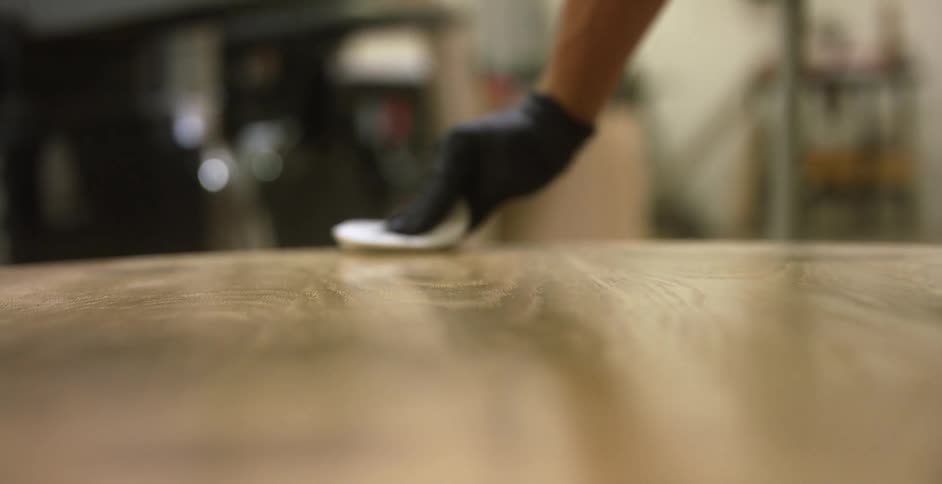A carpenter polishes a table