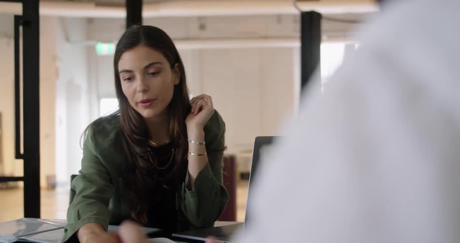 Two coworkers are talking together in an office