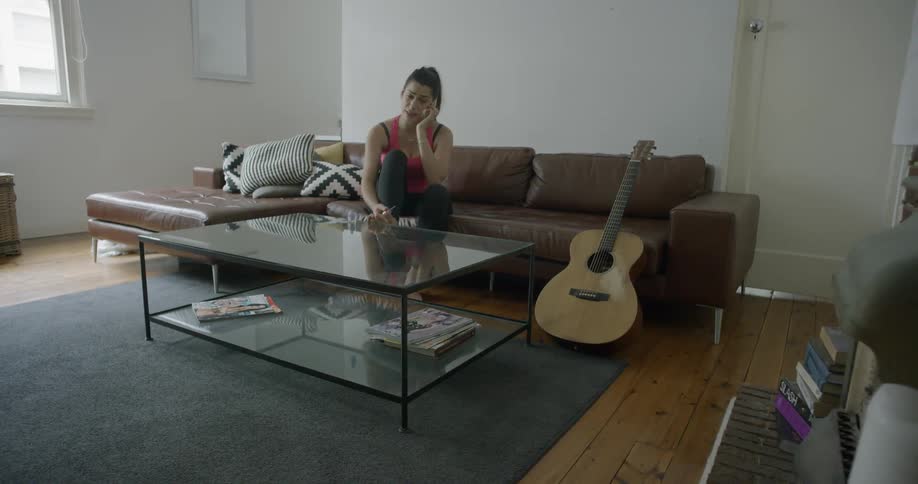 A woman sits polishing her nails and talking on the phone