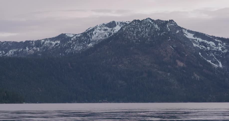 Lake along snow covered mountain range