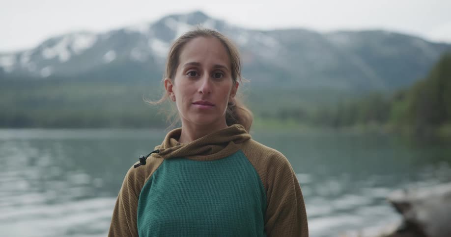 A woman standing outdoors near a river