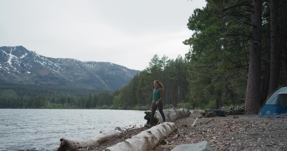 A woman walking out of a tent while camping