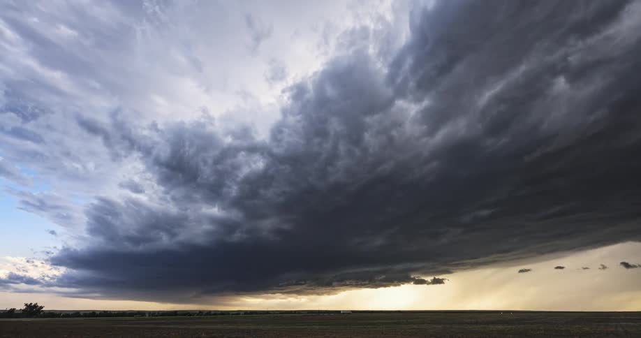 Dark storm clouds move over farmland
