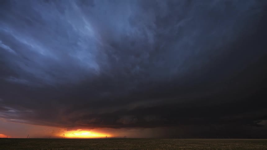 A time lapse shows enormous storm clouds rolling across the sky at sunset