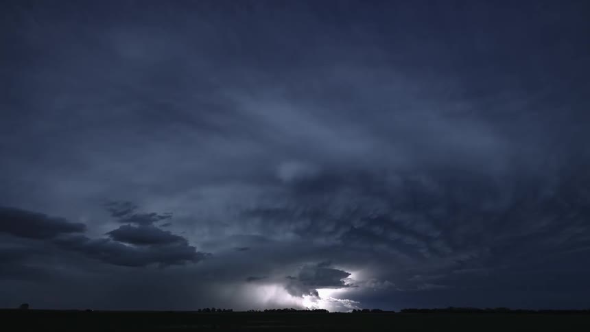 A landscape with trees lightning the sky and clouds in the background