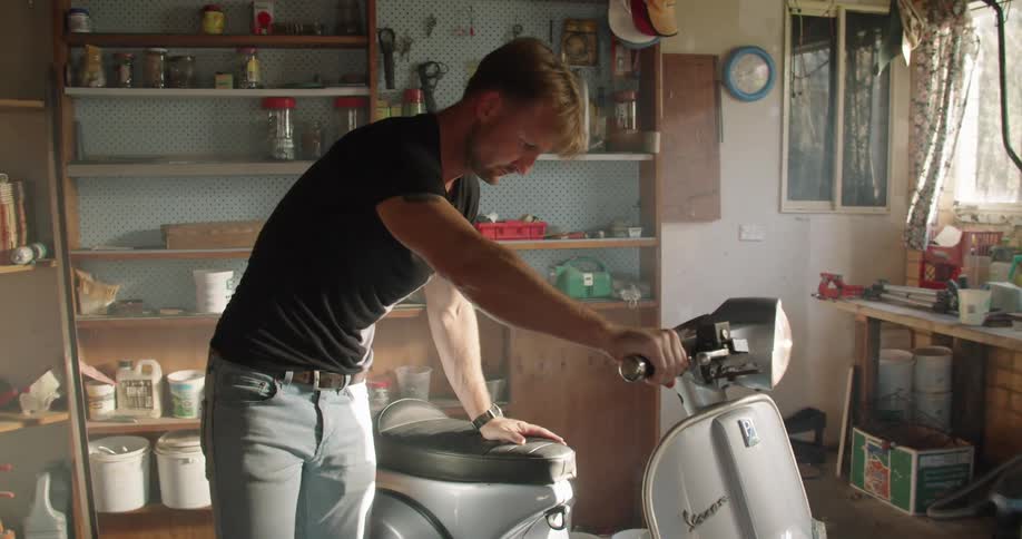 A man that is starting a scooter