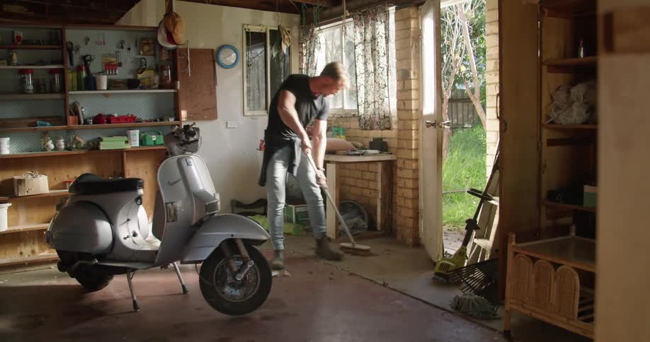 A man sweeps in his garage