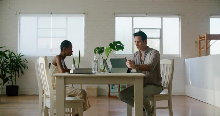 A man and woman talk and look at a tablet
