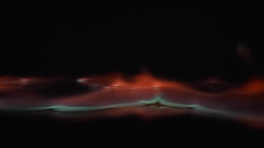 Orange blue flames burn close towards camera in a fluid movement