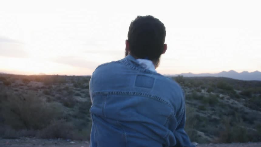 A man puts his jacket on outside