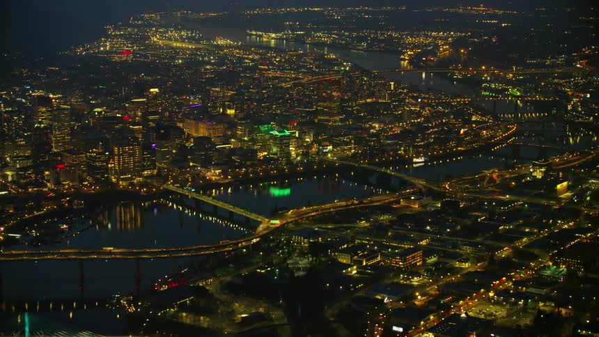 Stunning night aerial shot of downtown Portland Oregon with the Willamette River dividing downtown Portland with the neighborhoods to the southeast