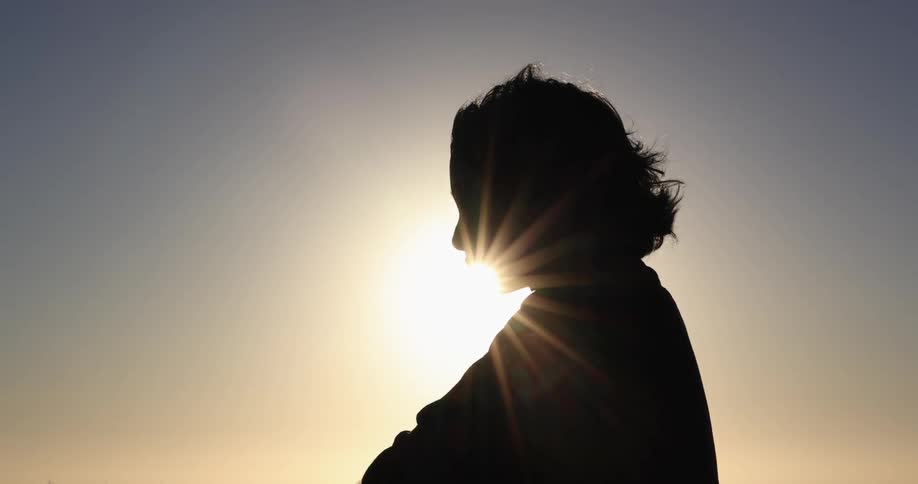 A woman is standing outside on a windy day