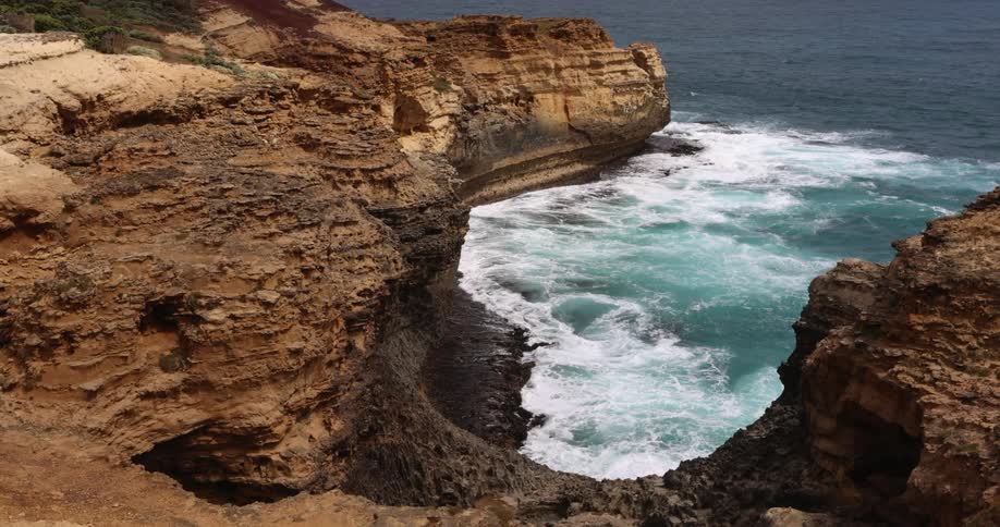 Ocean waves are moving towards the cliff