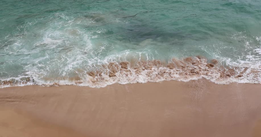 A beach with sand and waves