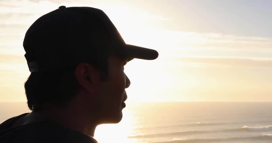 A man looks out at waves rolling in