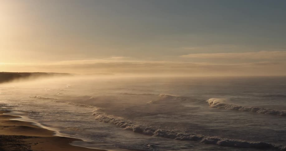 The sun is rising on the beach