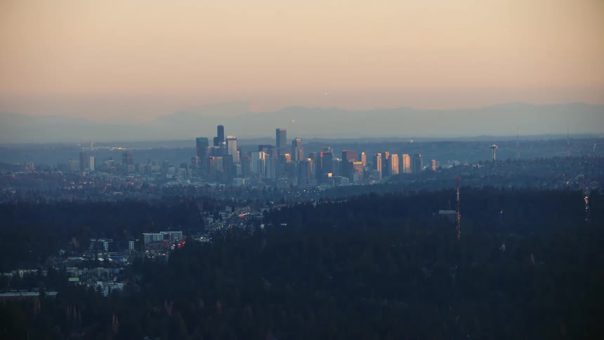 Downtown Seattle rises above the hills and trees at sunset in this aerial taken on a crisp and clear evening