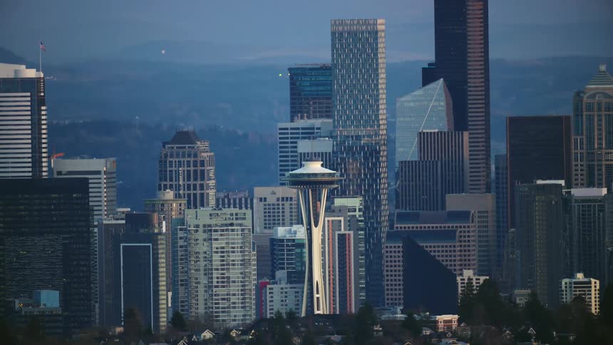 Tight Aerial shot of the Space Needle and other iconic Seattle downtown buildings as the camera rapidly flies across the city