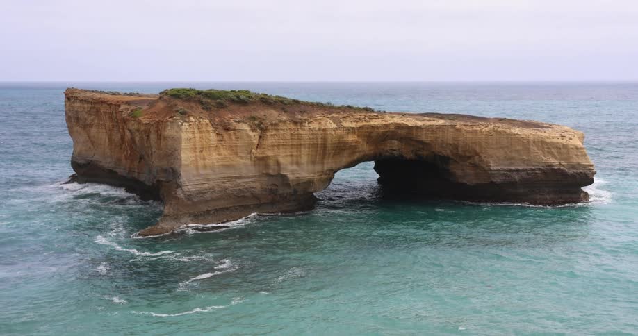 A large rock formation is in the ocean
