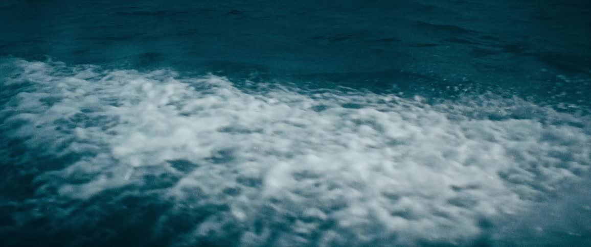 Rain falls onto rocky ocean waves