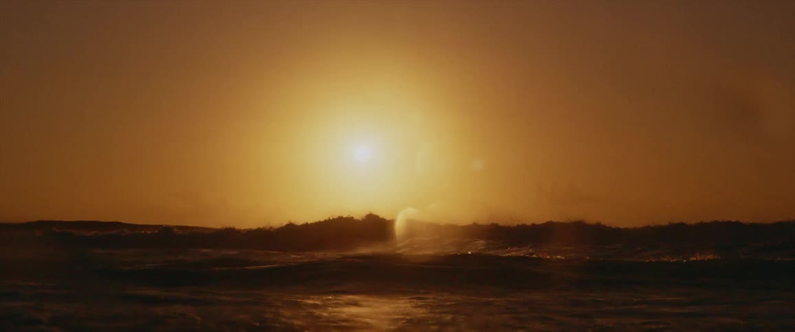 Sunset sunlight reflecting over the waves washing over the coast