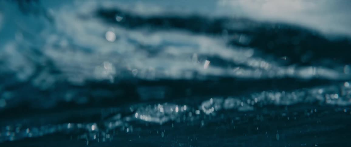 An ocean with waves of water with the sky and clouds in the background