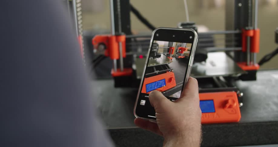 A man enlarges photos taken of 3d printers to zoom in on a section