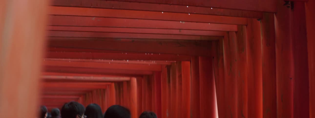 A group of people walk through a pillar archway