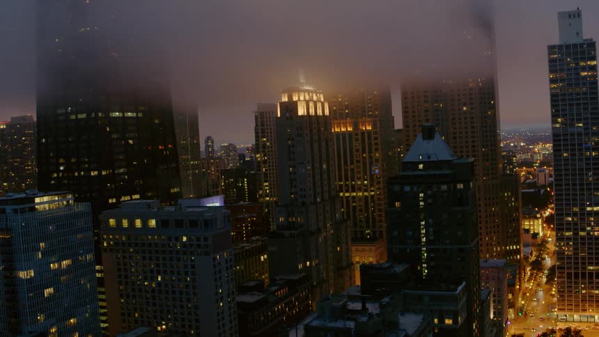 The clouds cover the tops of buildings in Chicago