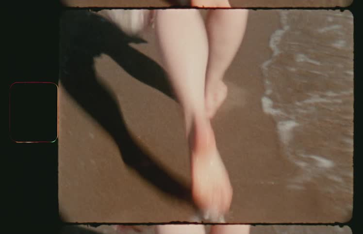 A womans feet walking on a sandy beach