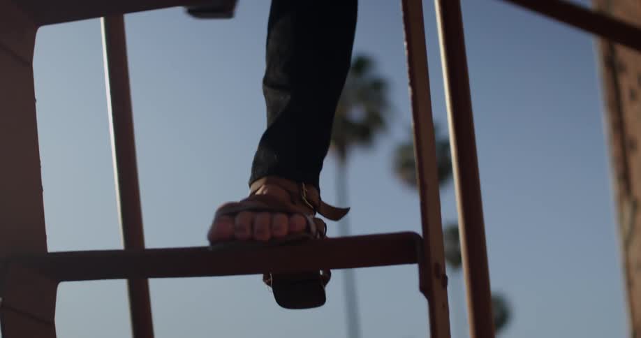 A person is climbing down a fire escape