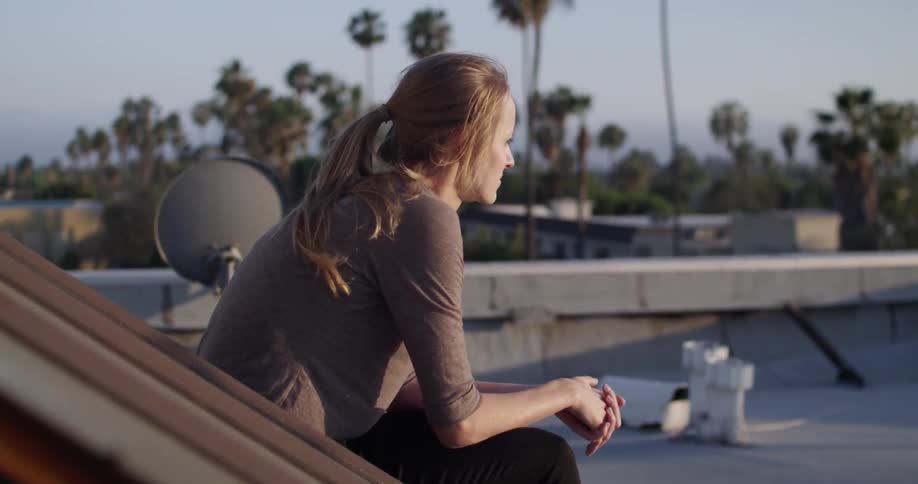 A woman sits down outside on a windy day