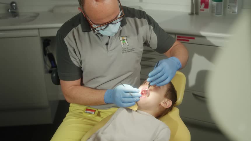 A dentist working on a childs teeth