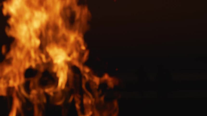 Orange and yellow flames on a bonfire at night