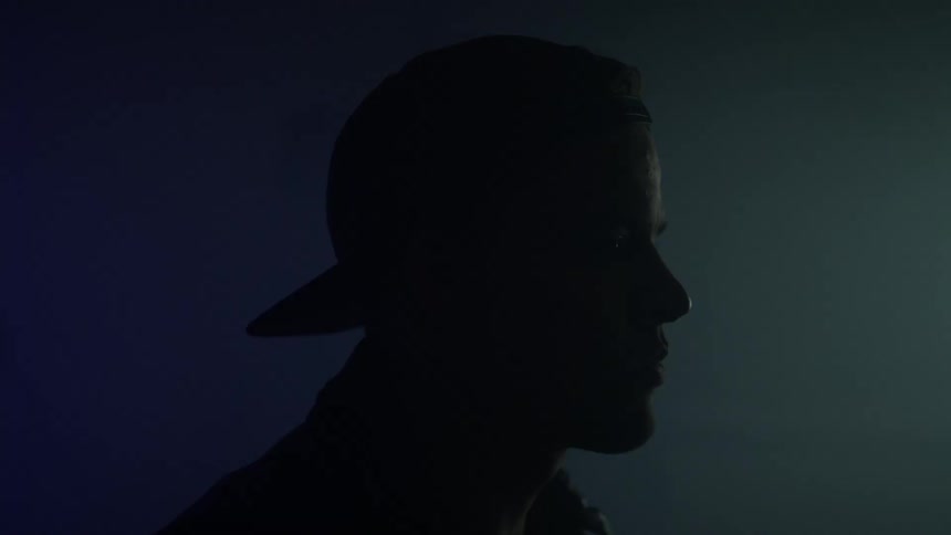 Blue and red lights shining behind a silhouetted head in darkness