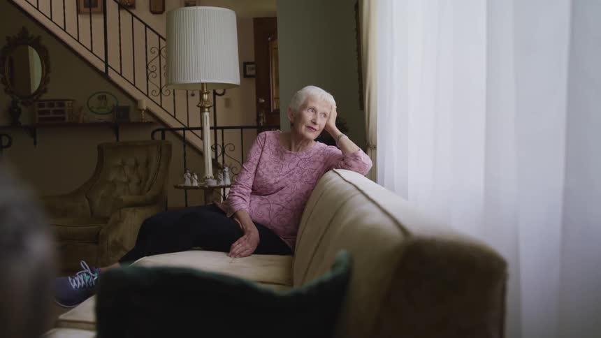 A woman sitting on a couch looking out a window
