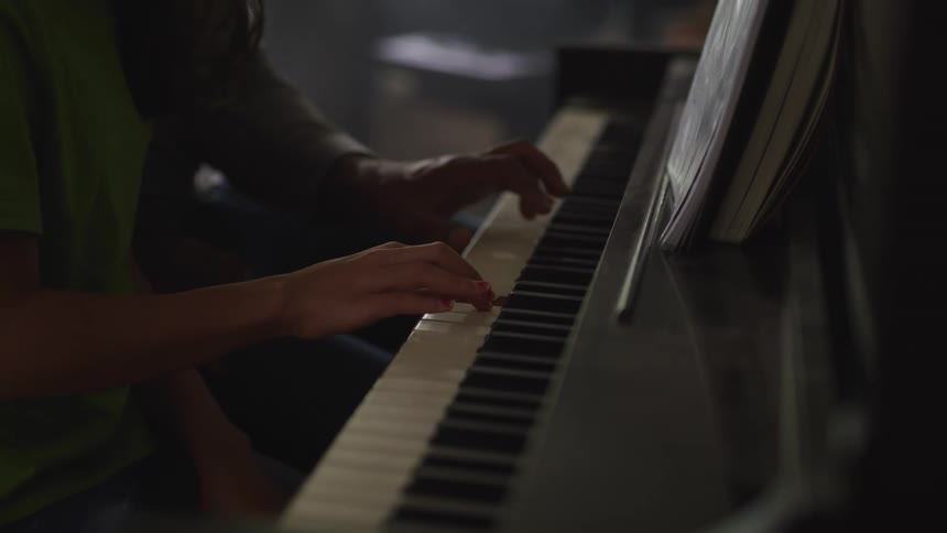 Father and daughter play the piano together