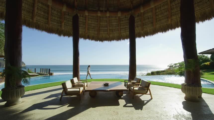 A woman walks along the shore at a resort