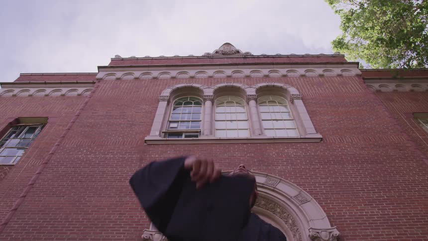 A student throwing off their graduation cap