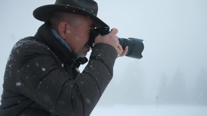 A man that is taking a photo in the snow