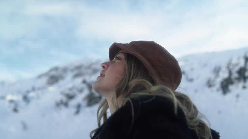 Young woman modeling for the camera in the snowy mountains