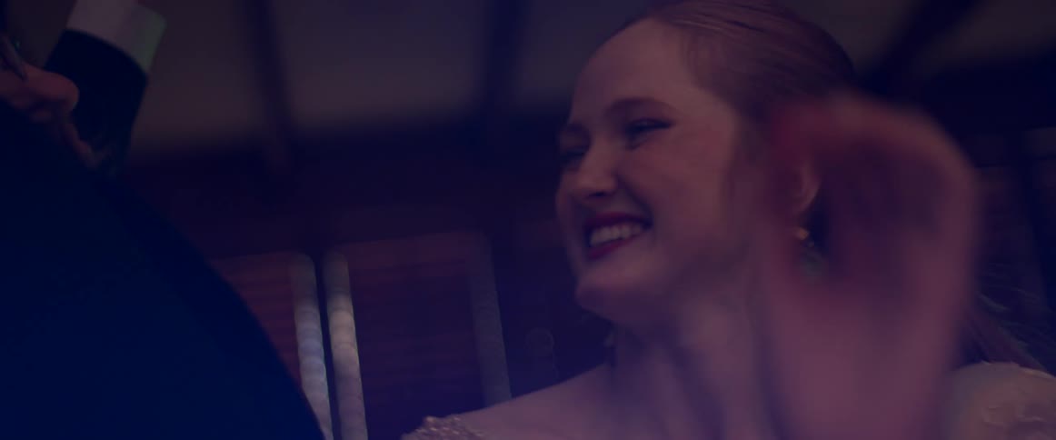 A man and woman laugh as they dance