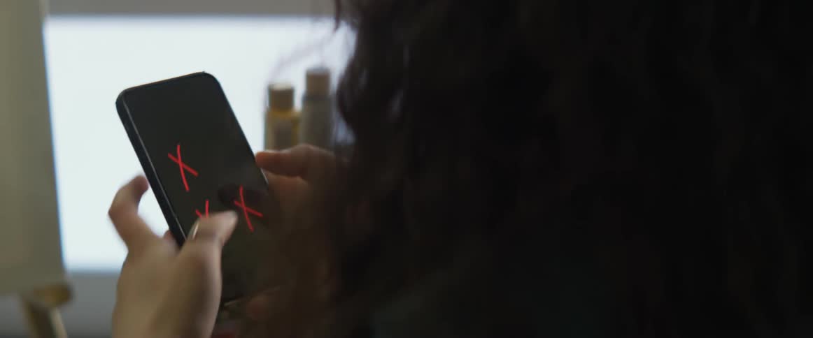 A woman typing on a smartphone screen